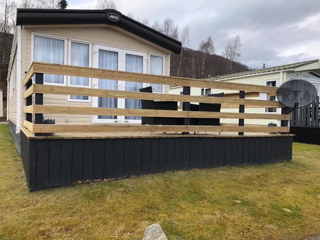 a wooden fence in front of a house at Coorie Nook, Chalet 103 in Aviemore