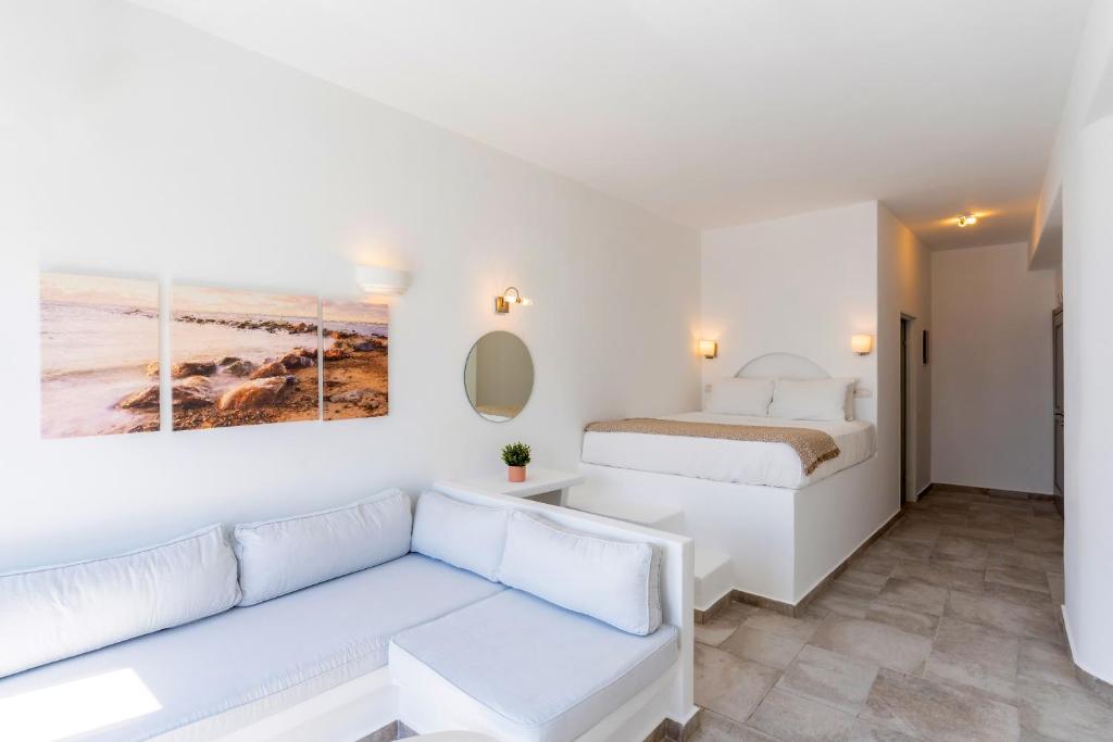 a white living room with a couch and a bed at Enalion White Suites Oia in Oia
