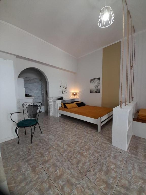 ein Schlafzimmer mit einem Bett und einem Stuhl darin in der Unterkunft Overhill Apartments Adamas in Adamas