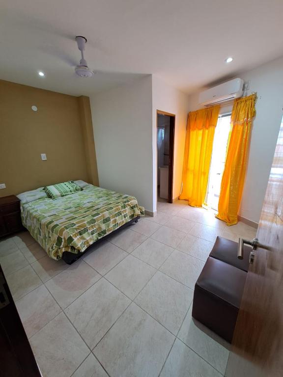 ein Schlafzimmer mit einem Bett und einem Sofa darin in der Unterkunft ALOJAMIENTO NORTE 1 in Santiago del Estero