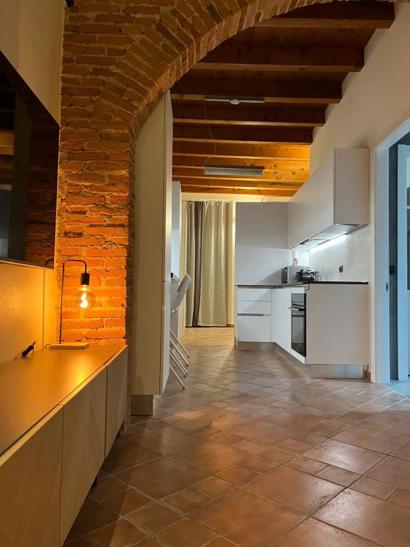 una cocina con armarios blancos y una pared de ladrillo en LA VOLTA - ANTESITUM - historic, on the lake, en Malgrate