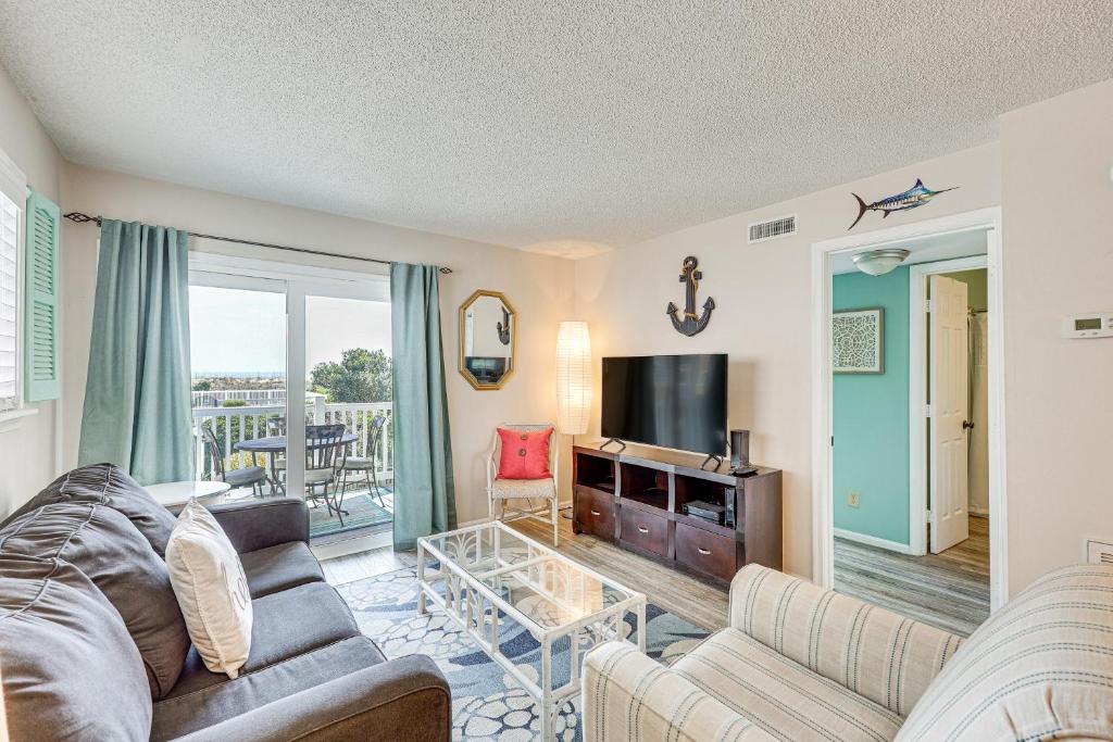 a living room with a couch and a table at Carolina Beach Condo with Balcony and Ocean Access! in Carolina Beach