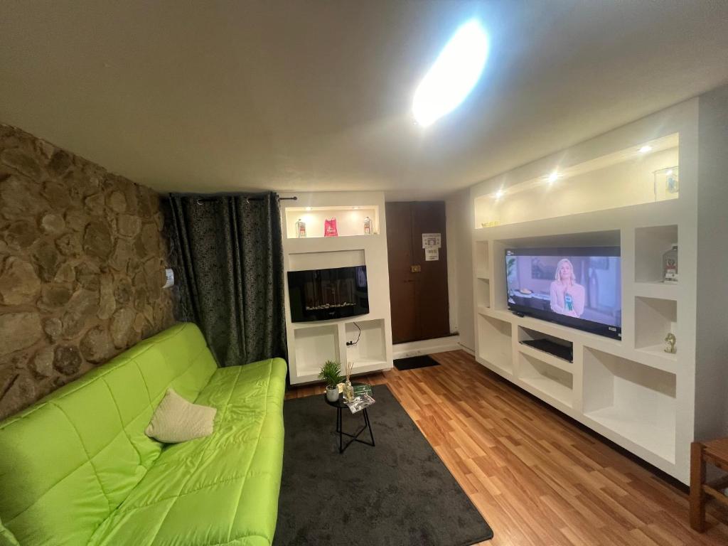 un soggiorno con divano verde e TV di La Maison Dell'Amour a Boville Ernica