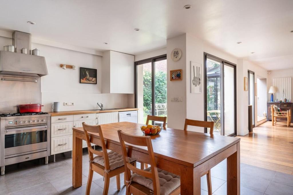 a kitchen with a wooden table and some chairs at Spectacular Family Home with GardenOlympiades in Paris