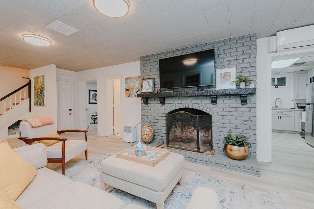 a living room with a brick fireplace with a tv at Marys Gatehouse Garden Apartment in Greensboro