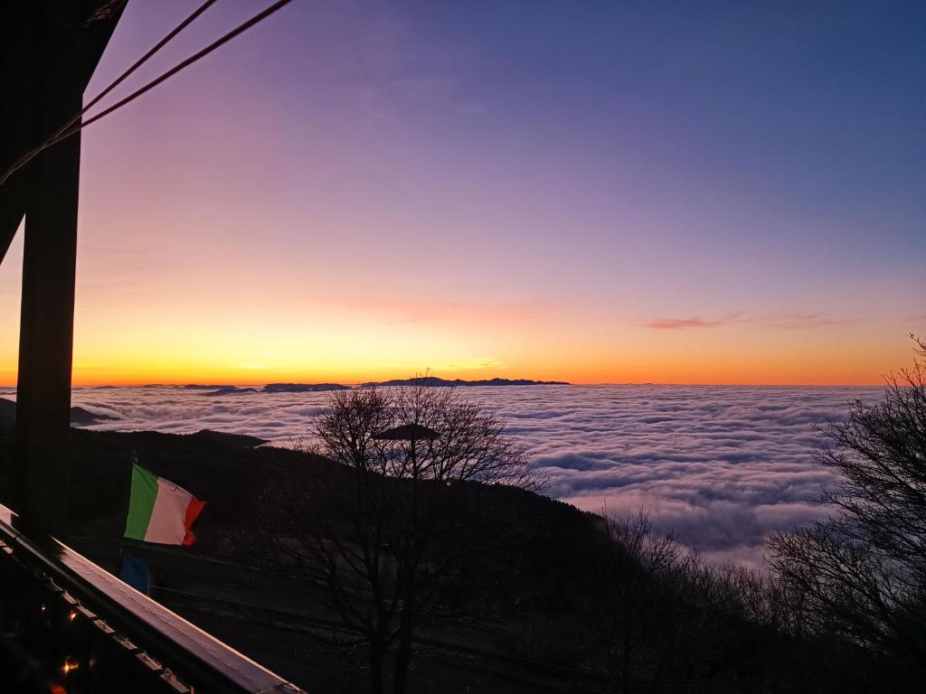a view of the sunset from above the clouds at Rifugio Guglielmo e Giovanni Pelizzo in Montemaggiore
