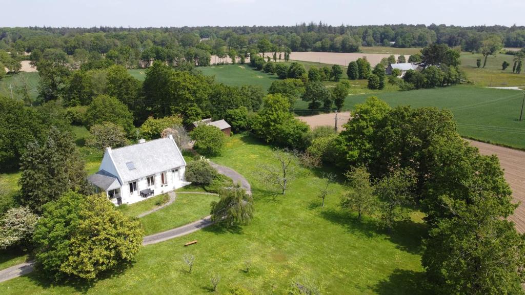 eine Luftansicht eines weißen Hauses auf einem grünen Feld in der Unterkunft Maison de 3 chambres avec piscine privee jardin clos et wifi a Paimpont in Paimpont