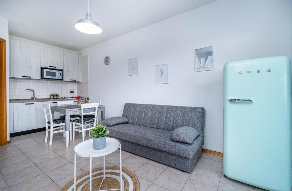 uma sala de estar com um sofá e uma cozinha em La Casetta di Bubi em Udine
