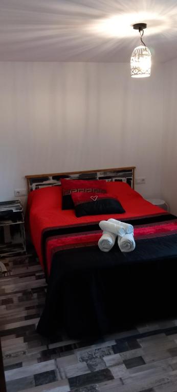a bedroom with a red bed with shoes on it at Casa da Eiriña in Amés