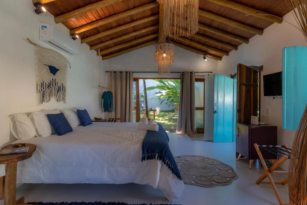 ein Schlafzimmer mit einem Bett und einem großen Fenster in der Unterkunft Villa Mediterrâneo Trancoso in Trancoso