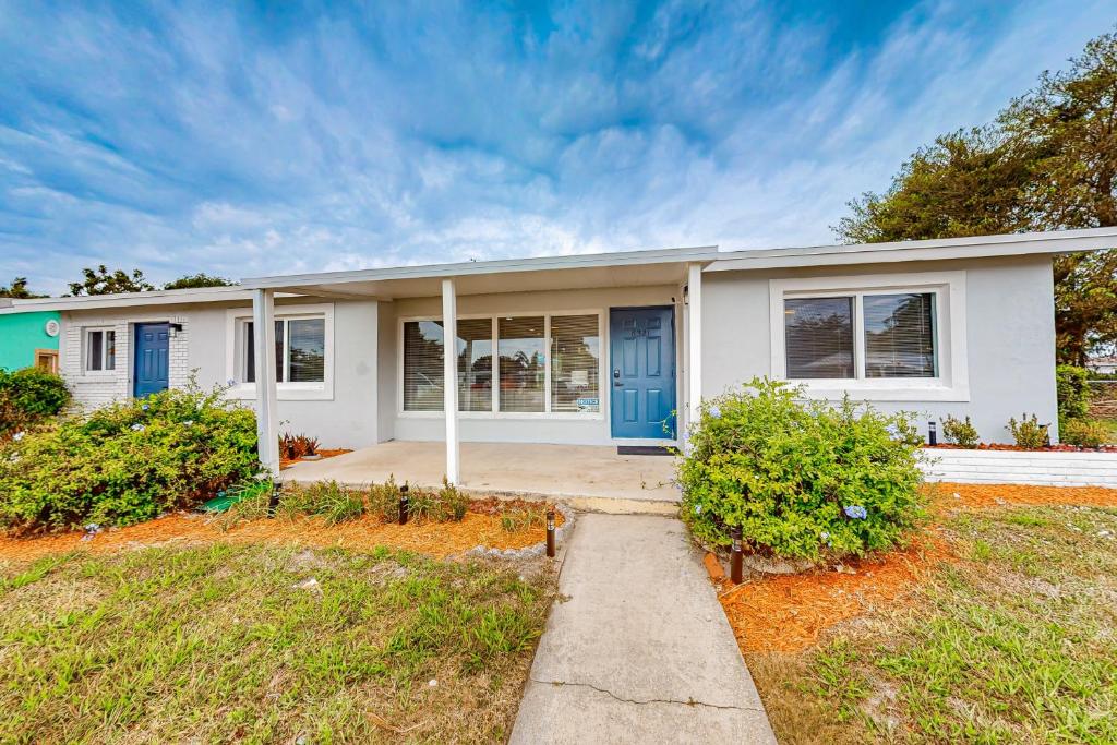 uma grande casa branca com uma porta azul em Palm Place em Lake Worth