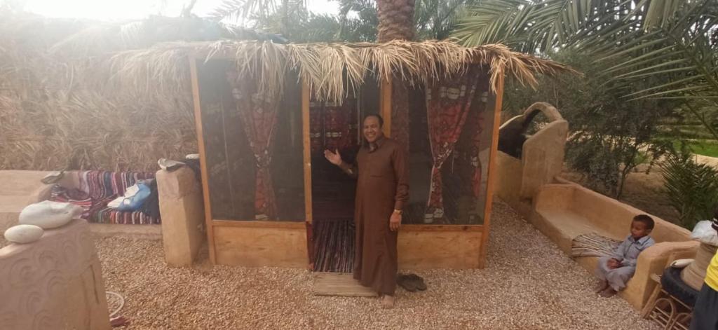 a man standing in front of a play house at siwa gardenia cottage in Siwa