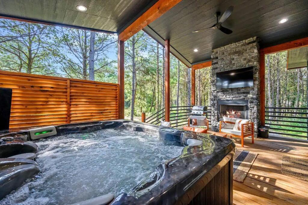a large hot tub in a room with a fireplace at 282 Timbuktu Cabin in Broken Bow