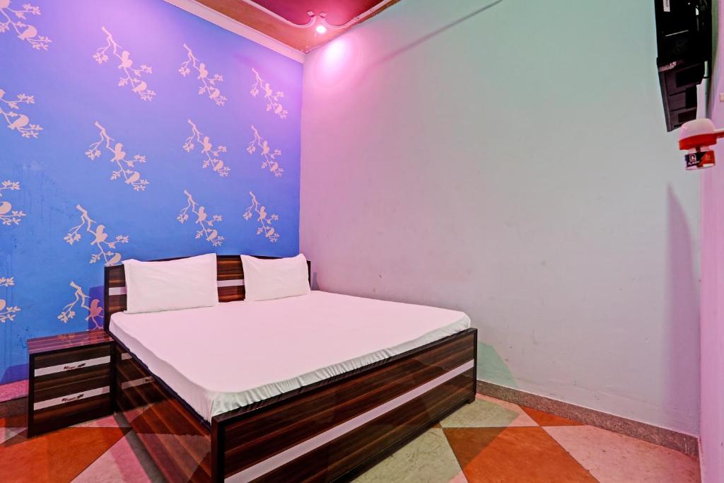 um pequeno quarto com uma cama num quarto em OYO Hotel The Paradise Inn em Jhajjar