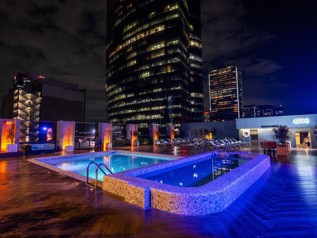 una piscina en medio de una ciudad por la noche en Galeria Plaza Reforma, en Ciudad de México