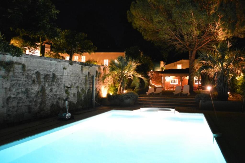 - une piscine en face d'une maison la nuit dans l'établissement Château La Tuilière Villa with pool and it's own wineyard, à Saint-Ciers-de-Canesse