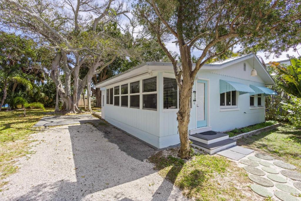 a white house with a tree in front of it at 29 Palms in Anna Maria