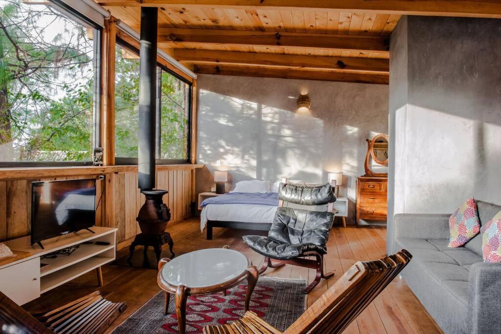 a living room with a couch and a tv at Wood Loft the Forest Espectacular loft de madera. in Valle de Bravo