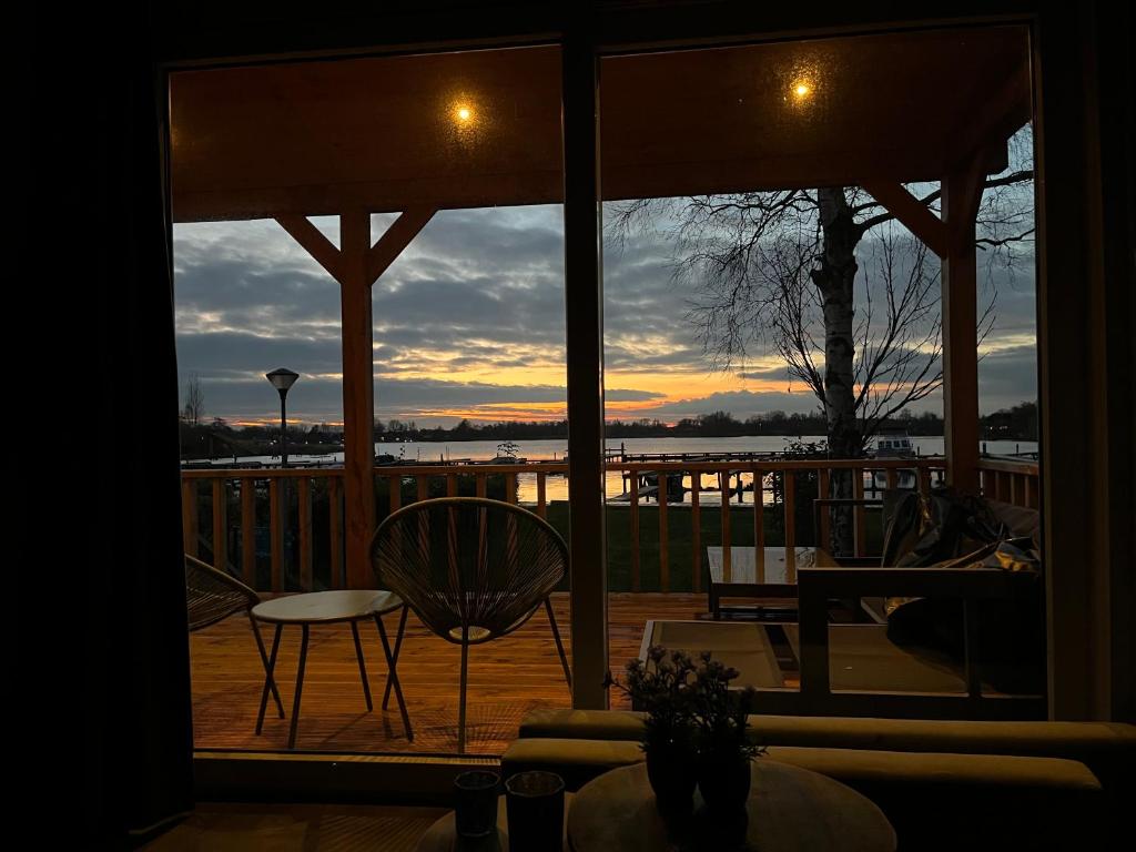 a view of a sunset from the porch of a house at Wiede lodge met uitzicht over het water in Belt-Schutsloot
