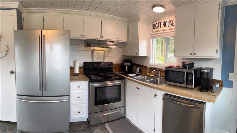 a kitchen with white cabinets and stainless steel appliances at Beautiful Oceanview Retreat 2 Bedroom Home in Port Hadlock