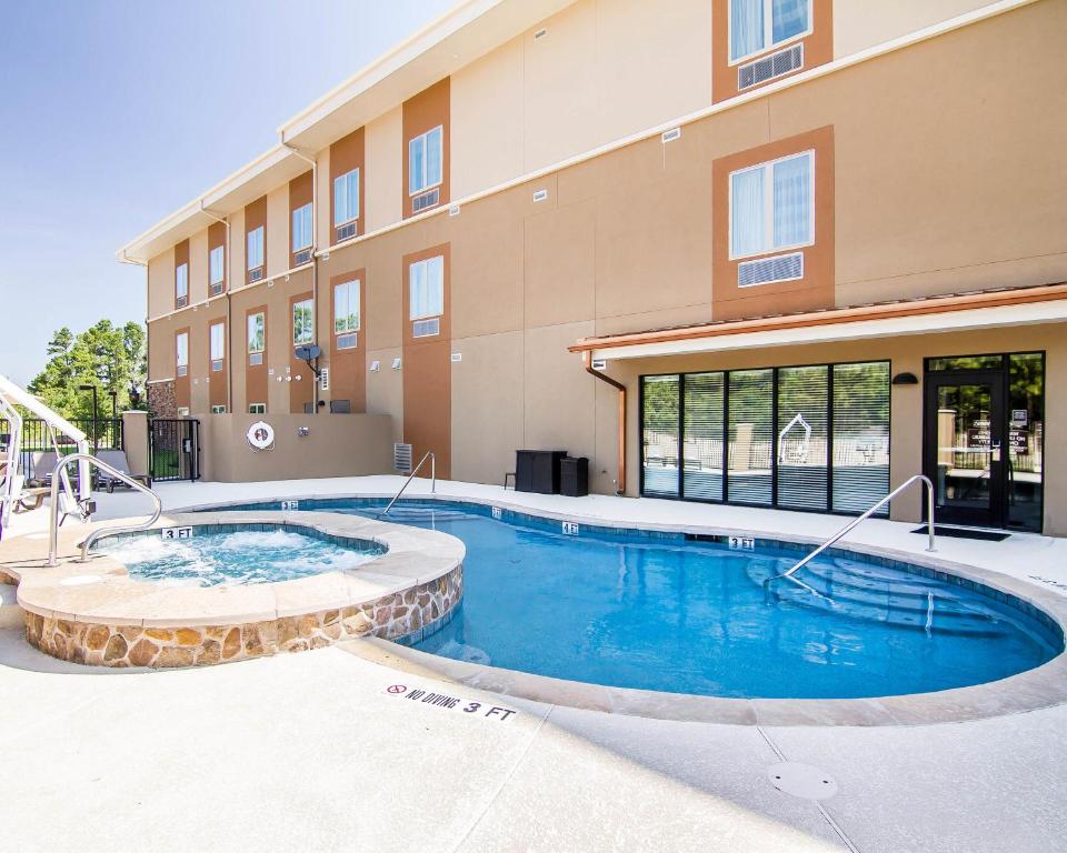 a building with a swimming pool in front of a building at Sleep Inn Lufkin in Lufkin