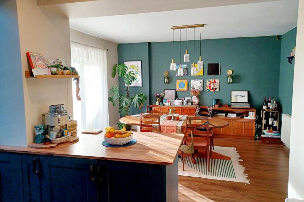リバプールにあるMajestic! Beautiful home in a posh neighbourhoodの緑の壁のキッチン、テーブル(フルーツボウル付)