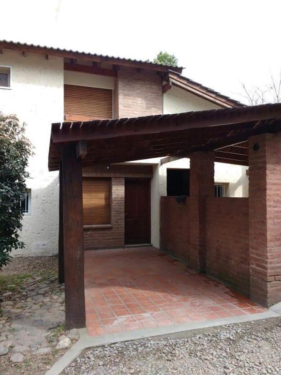 ビジャ・ヘネラル・ベルグラーノにあるSanta Juliaのレンガ造りの家で、正面に大きなパティオがあります。