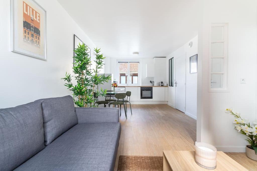 ein Wohnzimmer mit einem Sofa und einem Tisch in der Unterkunft Lille - Bel Appartement Cosy et Lumineux in Lille