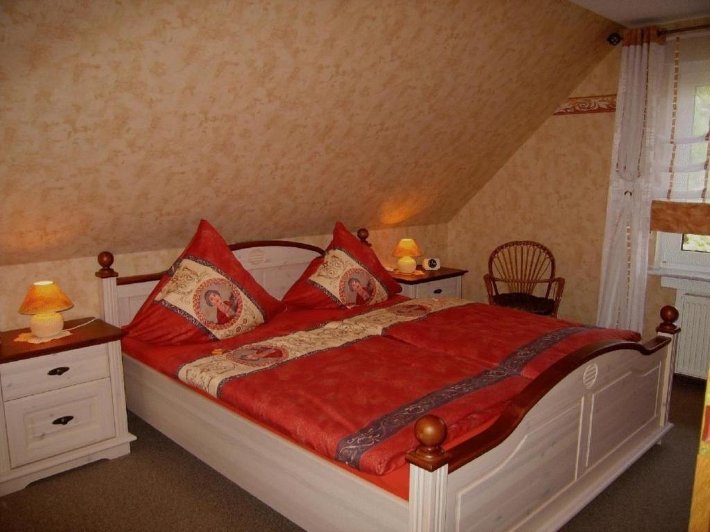 1 dormitorio con 1 cama grande con almohadas rojas en Exklusive Ferienwohnung in Wilhelmsfehn mit Garten, Grill und Terrasse, en Wiesmoor