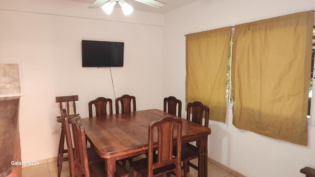 a dining room with a wooden table and chairs at Cabañas La Dorita in Paso de la Patria
