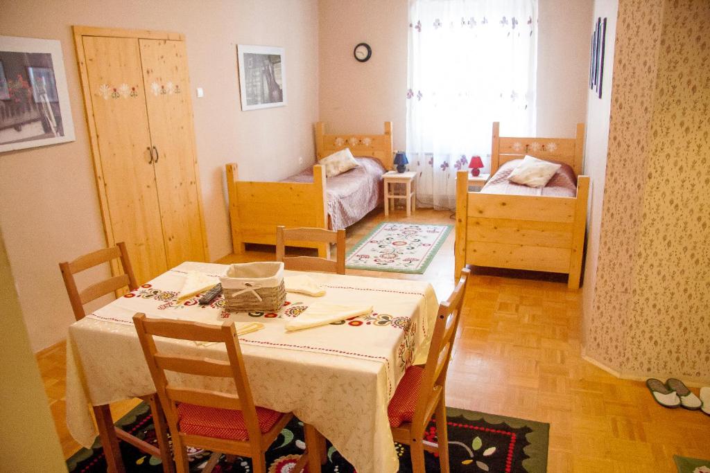 uma sala de jantar com mesa e cadeiras e um quarto em Baščaršija Apartments & Rooms em Maribor