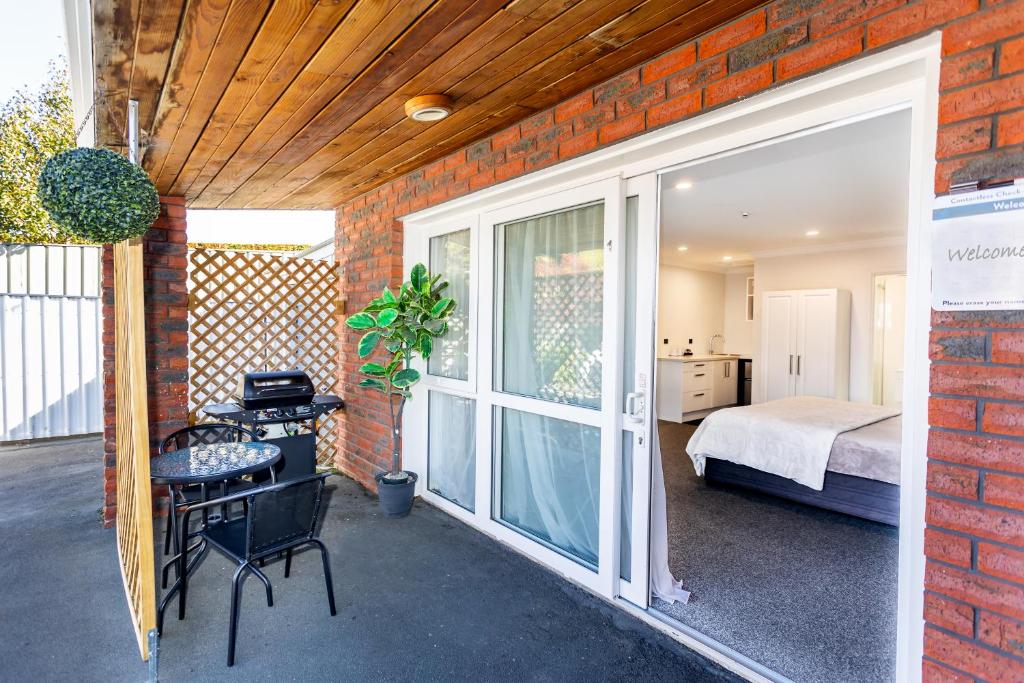 um quarto com um quarto, uma cama e uma janela em Superior Dunedin Apartments em Dunedin