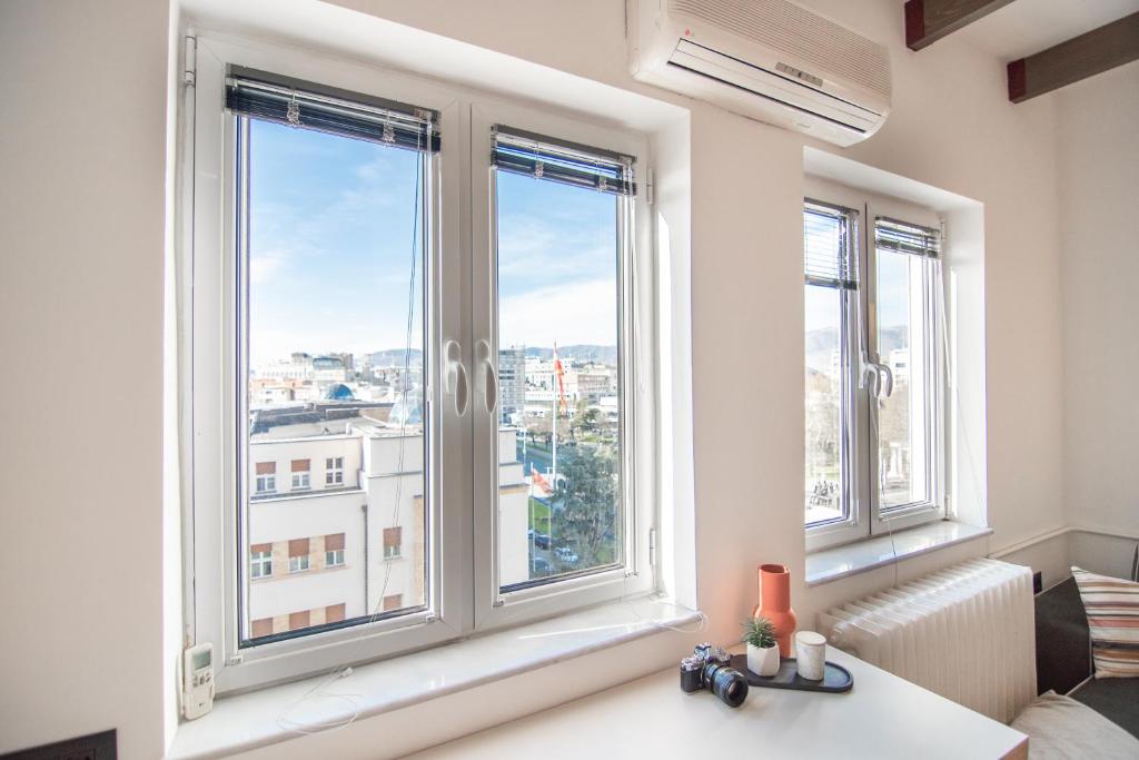 Cette chambre dispose de fenêtres offrant une vue sur la ville. dans l'établissement Dimov Center Apartment, à Skopje
