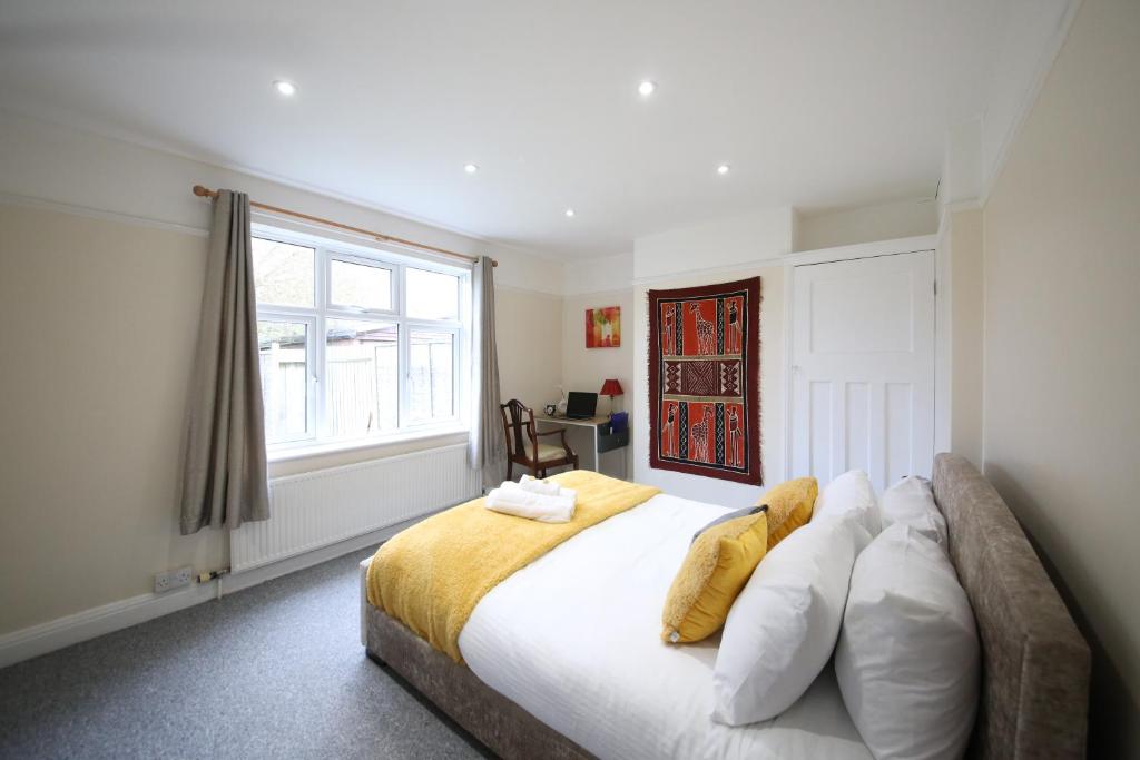 Un dormitorio con una gran cama blanca con ventana. en Thornton House Apartments, Cambridge - FREE On-site Parking, en Girton