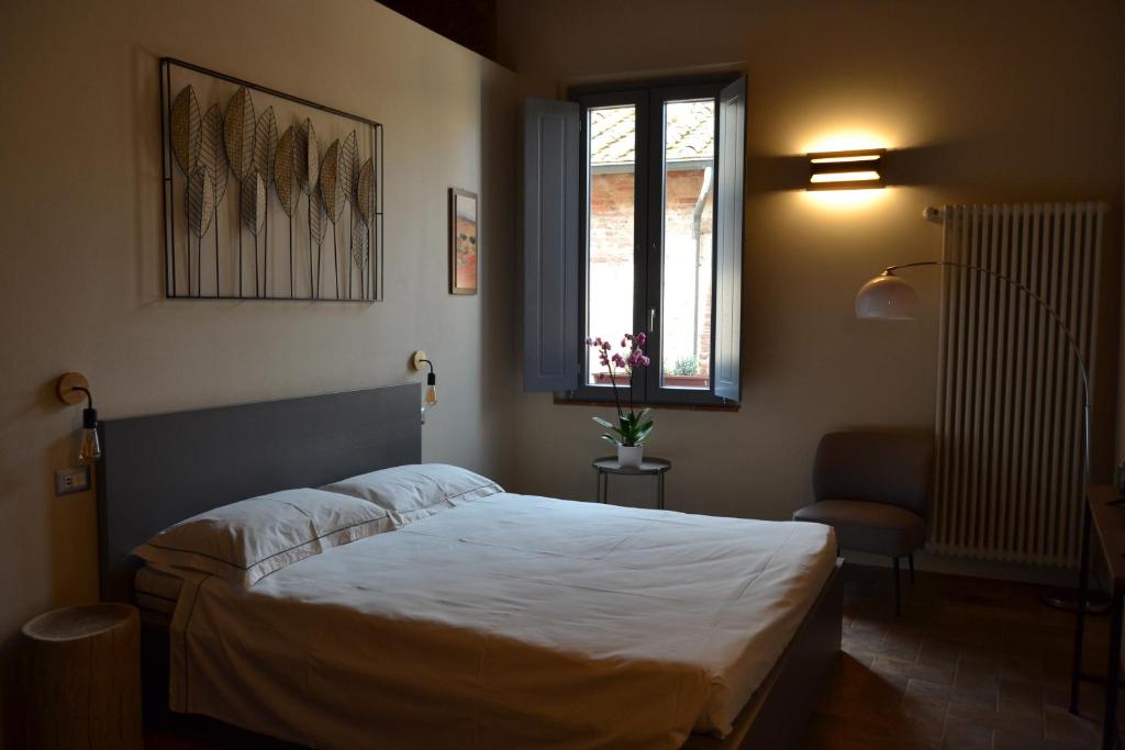 a bedroom with a large bed and a window at Pagum Place in Torrita di Siena