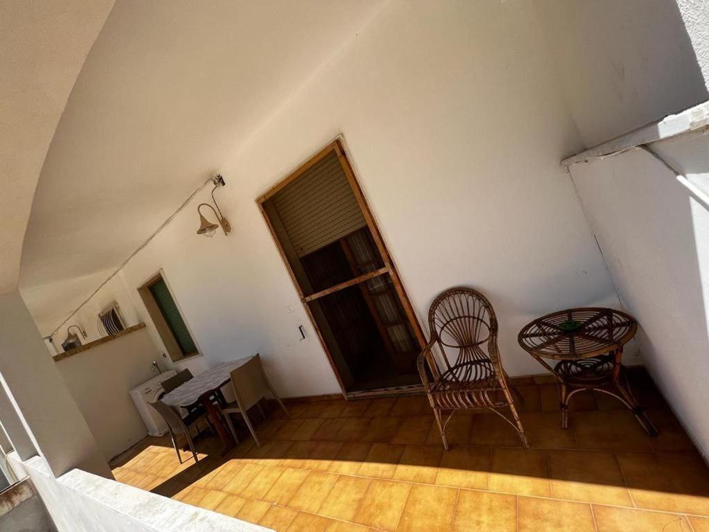 Habitación con 2 sillas, mesa y puerta en Appartamento Evelynn, en Pizzo