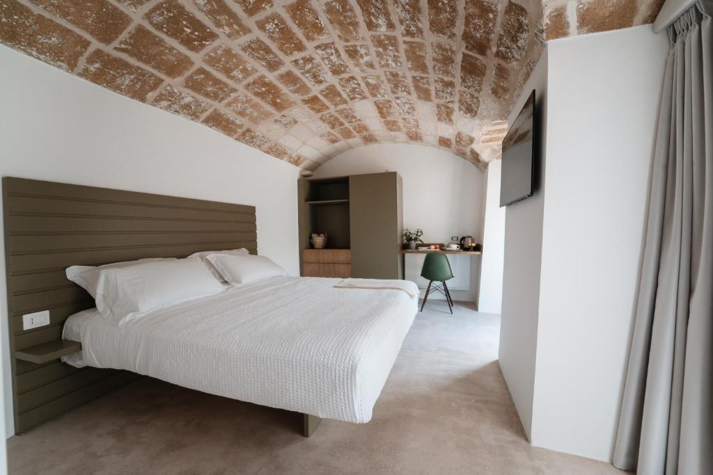 een slaapkamer met een bed en een stenen plafond bij La Vacia Boutique Country Resort in Pulsano
