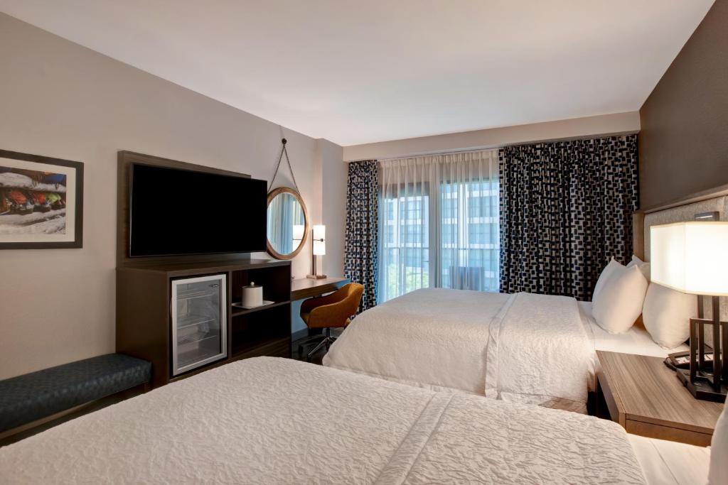 um quarto de hotel com duas camas e uma televisão de ecrã plano em Hampton Inn Austin East Side em Austin