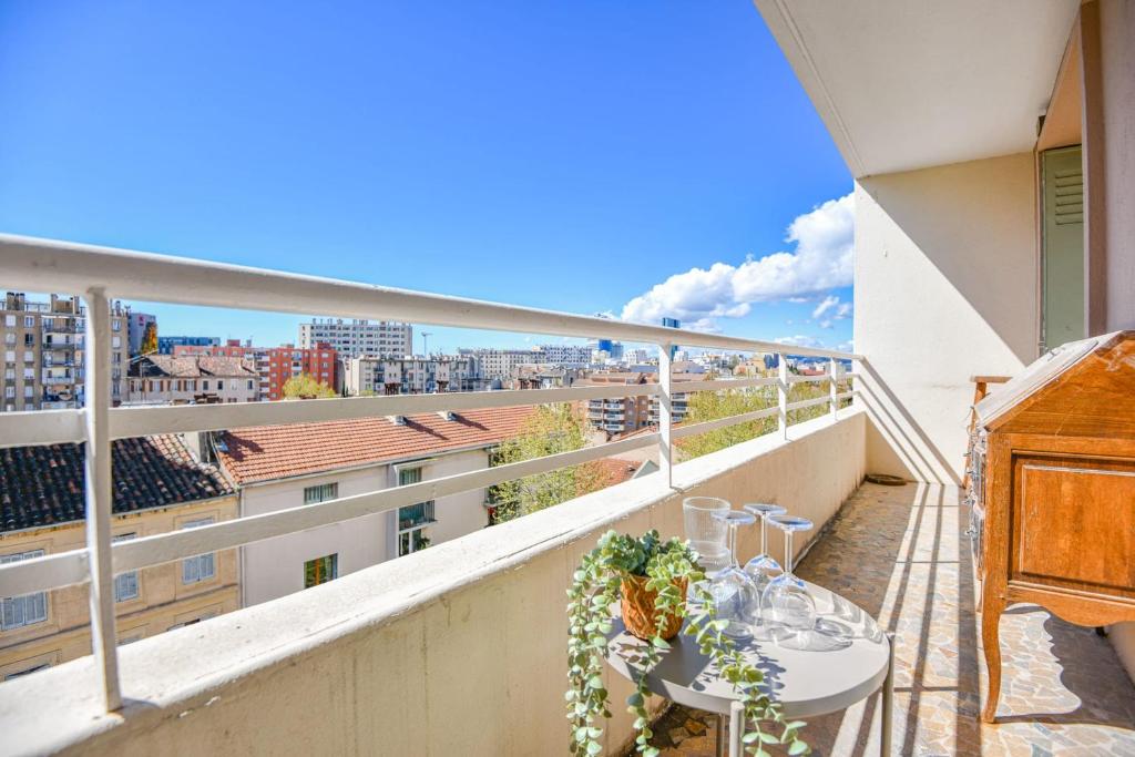 un balcon avec une table et une vue sur une ville dans l'établissement Appart 3 ch neuf proche Saint-Charles Belle de Mai, à Marseille