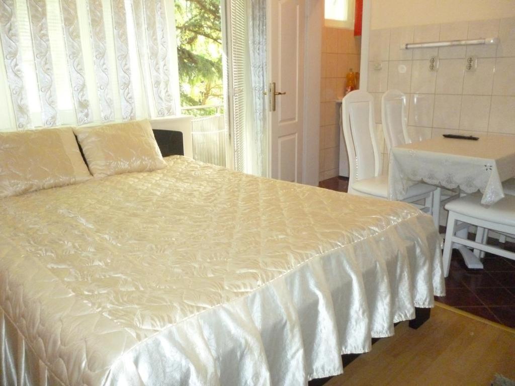 una camera da letto con un letto bianco con un tavolo e delle sedie di Apartment Gino a Ohrid