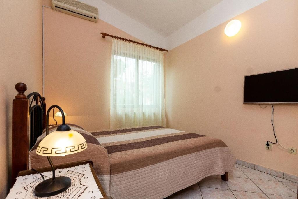 1 dormitorio con 1 cama y TV de pantalla plana en Ferienwohnung für zwei Personen, en Fažana