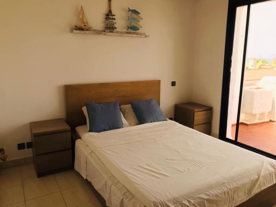 My Cosy Place Rabat - Maison harhoura vue mer في تمارة: غرفة نوم بسرير كبير مع وسائد زرقاء