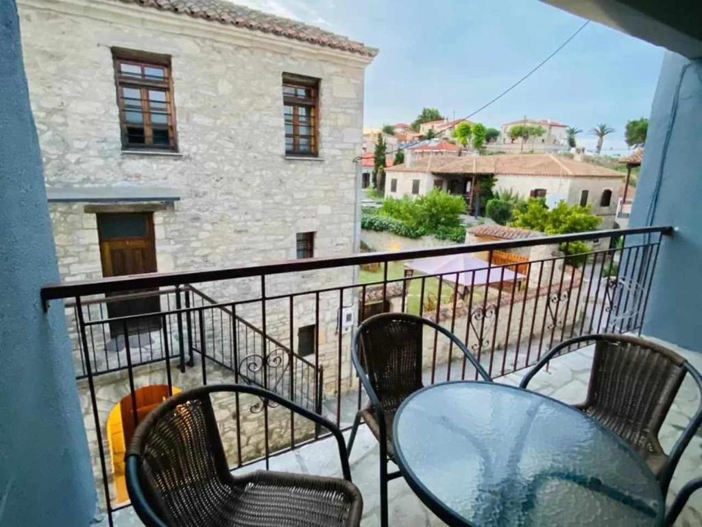 a balcony with chairs and a table and a building at Alexandros apartments in Afitos