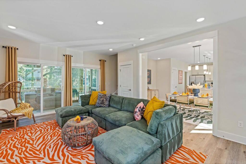 a living room with a green couch and a zebra rug at 3bd Contemporary in Raleigh: 5mins to Downtown in Raleigh