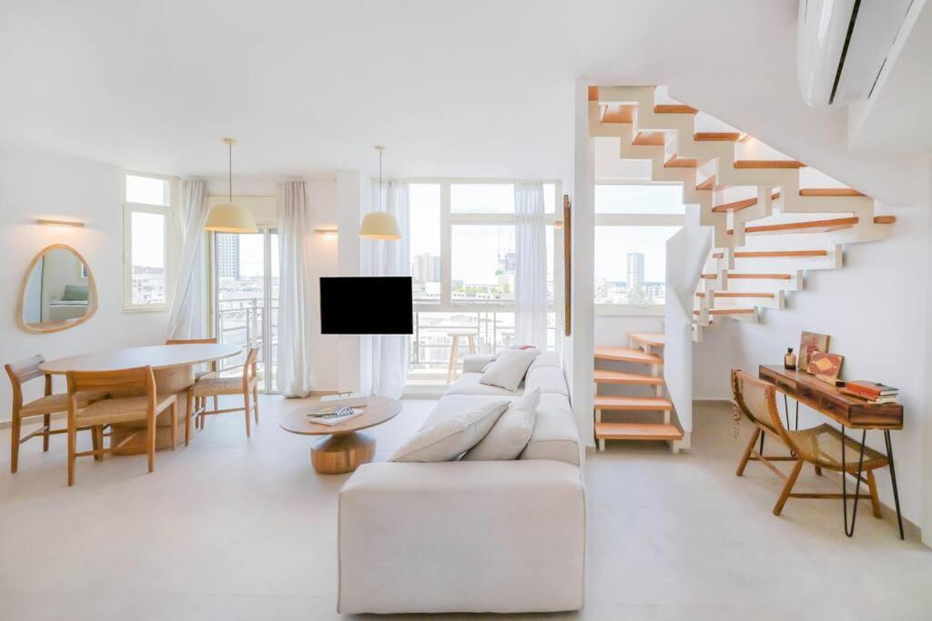 - un salon avec un canapé blanc et des escaliers dans l'établissement Mykonos Vibes - 3 BR, à Tel Aviv