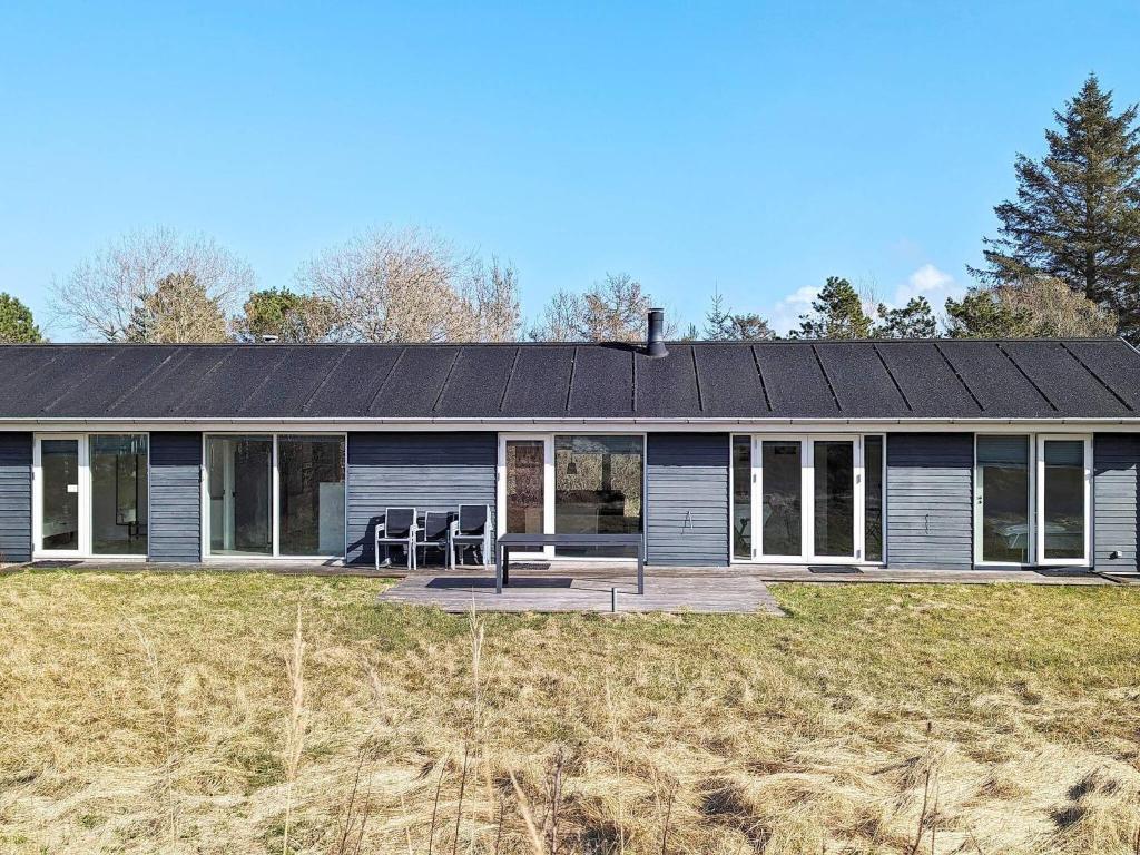 uma casa com um telhado solar num campo em Four-Bedroom Holiday home in Ålbæk 4 em Ålbæk