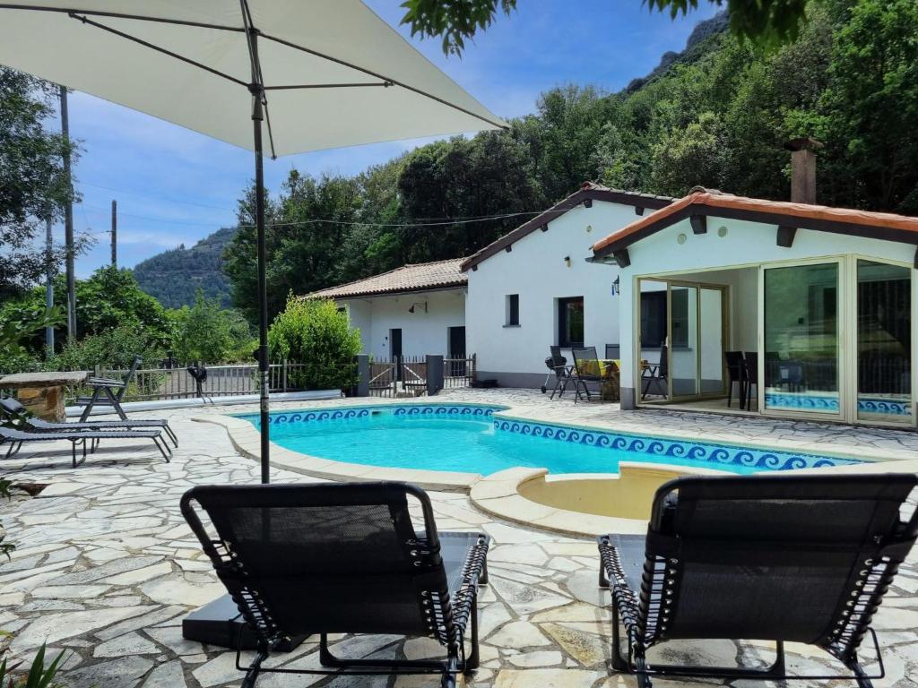 eine Villa mit einem Pool und einem Haus in der Unterkunft Le Castelas in Boisset