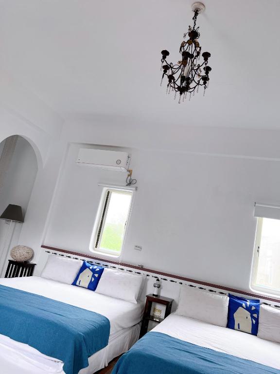 a bedroom with two beds and a chandelier at Greek Frontier Villa in Magong