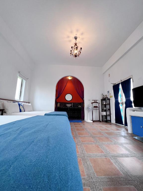 a bedroom with a large bed and a chandelier at Greek Frontier Villa in Magong