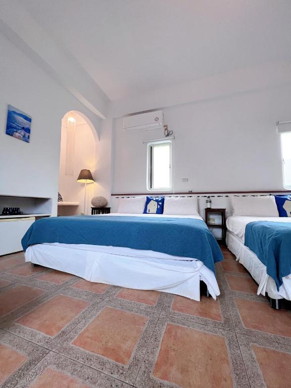 a white bedroom with two beds and a window at Greek Frontier Villa in Magong